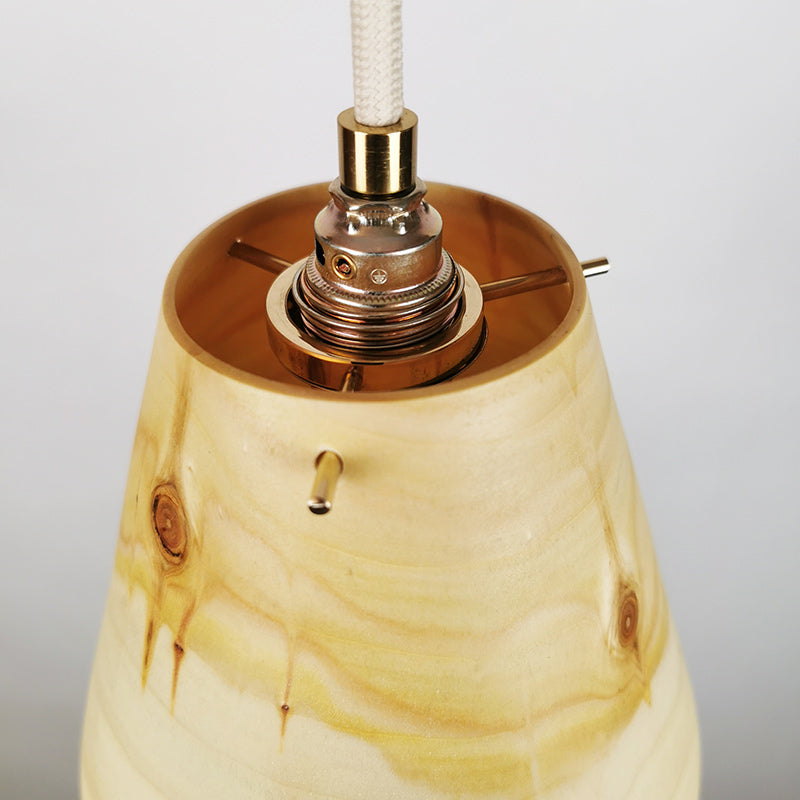Messingfassung mit Stoffkabel an einer Holzlamoe, von Hand gedrechselt.